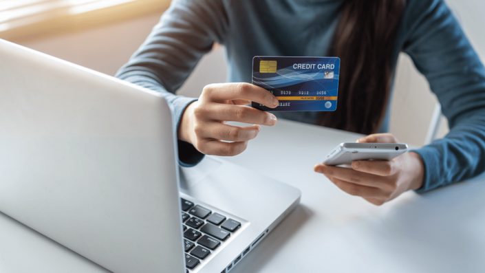 Persona utilizando una plataforma digital para realizar un pago con su tarjeta de crédito, ilustrando los errores comunes al usar tarjetas de crédito y cómo gestionarlos adecuadamente.