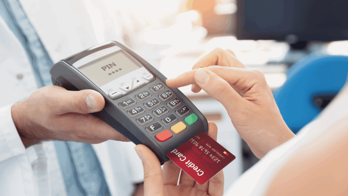 Mano insertando una de las Tarjetas para principiantes en una terminal punto de venta para realizar un pago.