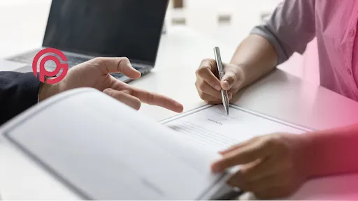 la mano de una persona señala un contrato donde la mano de otra persona firmará