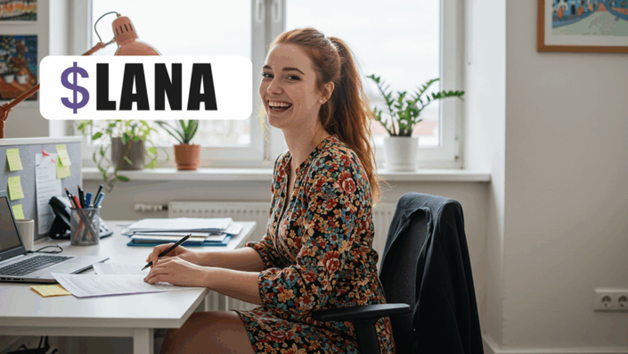 Mujer sonriendo mientras trabaja en su escritorio con una computadora portátil, rodeada de plantas y papeles. El logotipo de $LANA aparece en la parte superior izquierda de la imagen.
