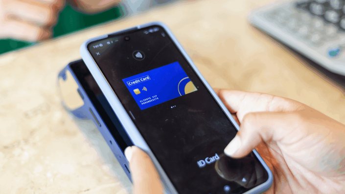 Primer plano de un pago sin contacto usando una de las tarjetas de crédito virtuales en México en un smartphone sobre una terminal punto de venta.