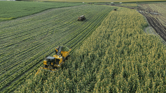 Comparativa visual en un campo de cultivo entre un tractor antiguo y oxidado y uno nuevo y tecnológico, mostrando la modernización que permite un Crédito refaccionario.